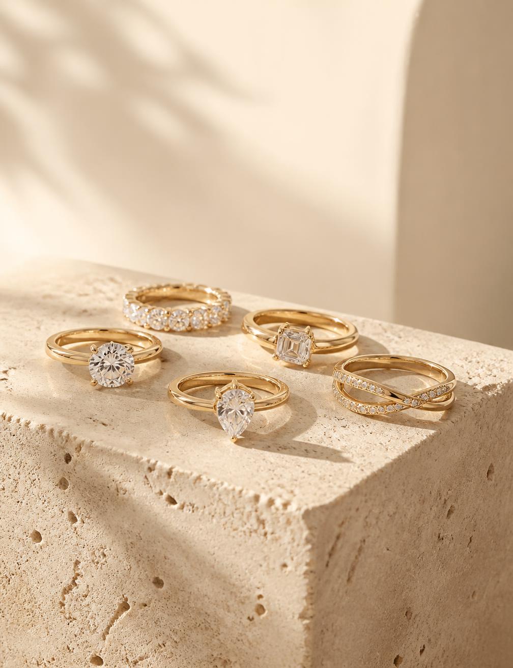 A group of fine gold diamond rings on travertine